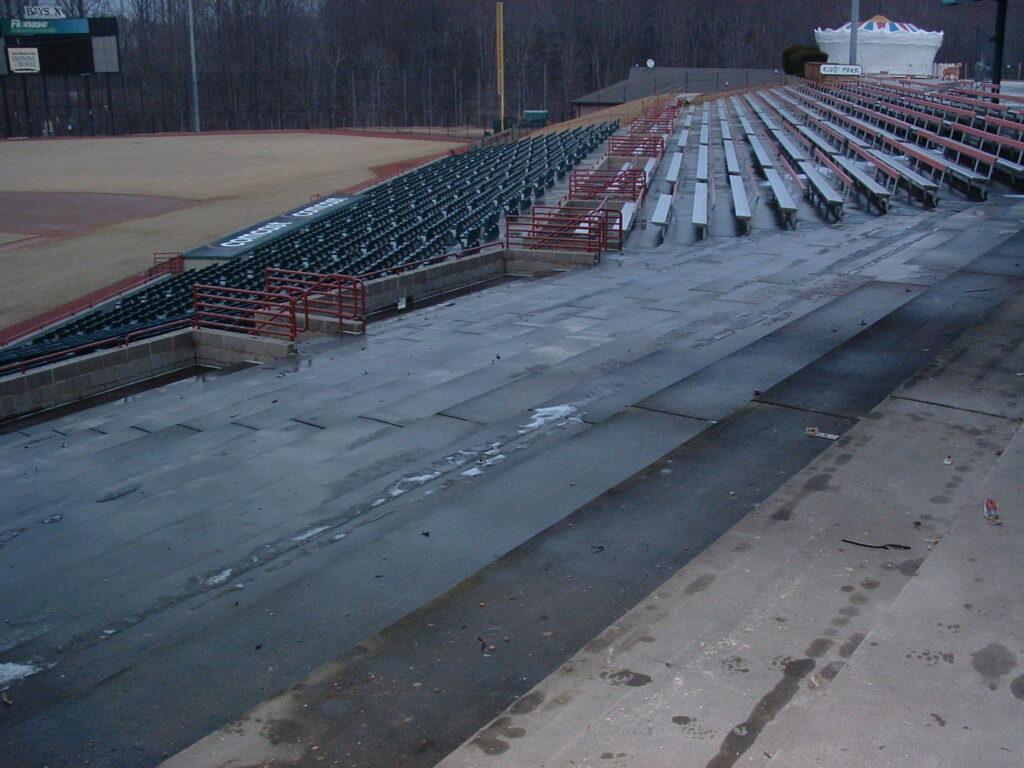 Outdoor stadium seating area undergoing heavy cleaning.