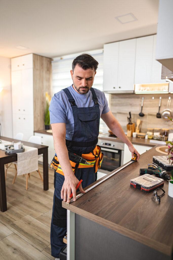 Contractor cutting countertop materials in a kitchen renovation.