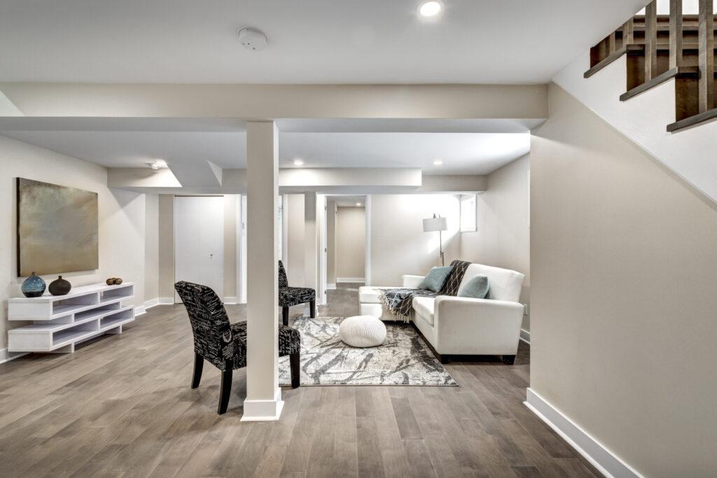 Bright finished basement with recessed lighting and modern flooring.