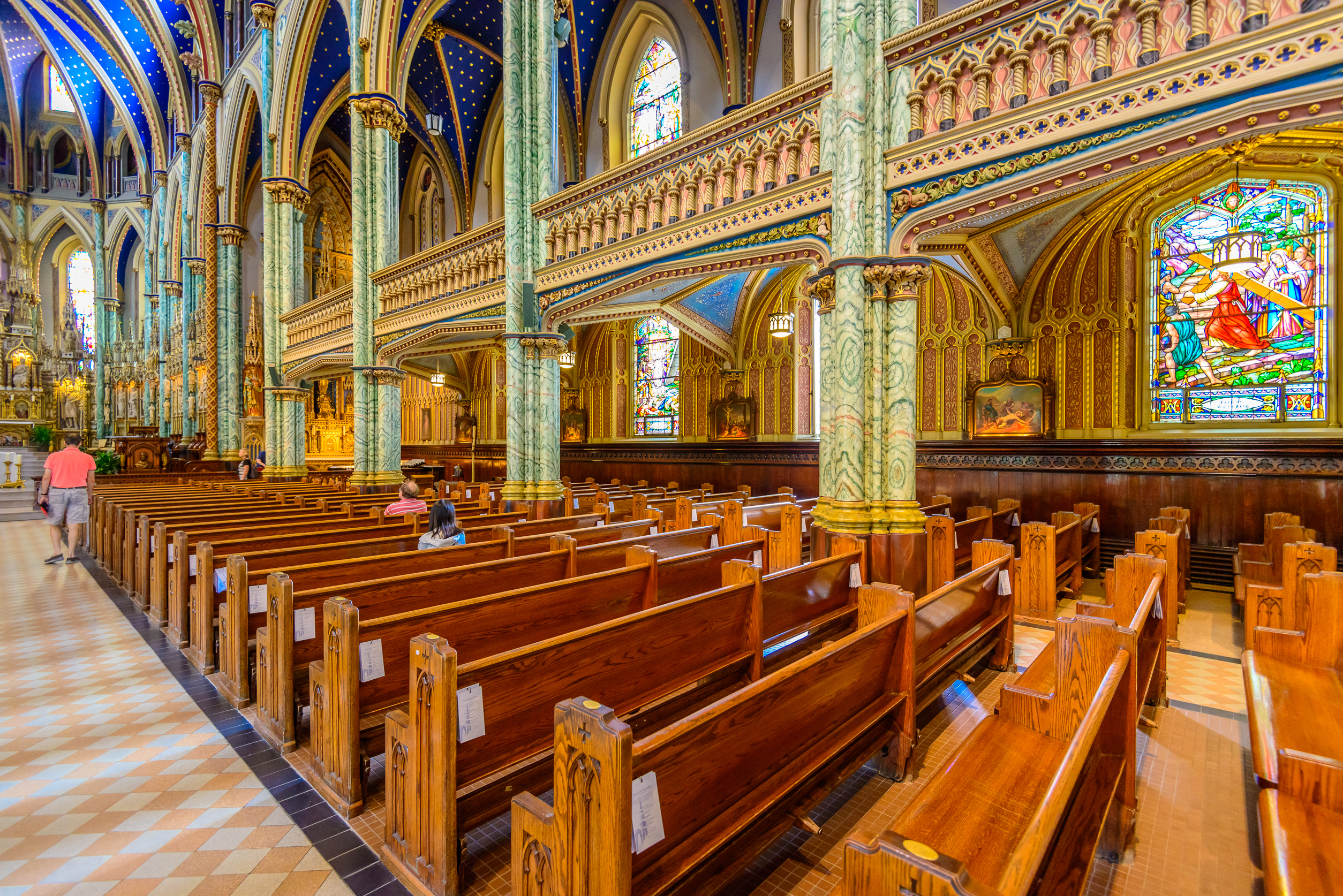 Interior of a historic cathedral featuring ornate vaulted ceilings and wooden pews.