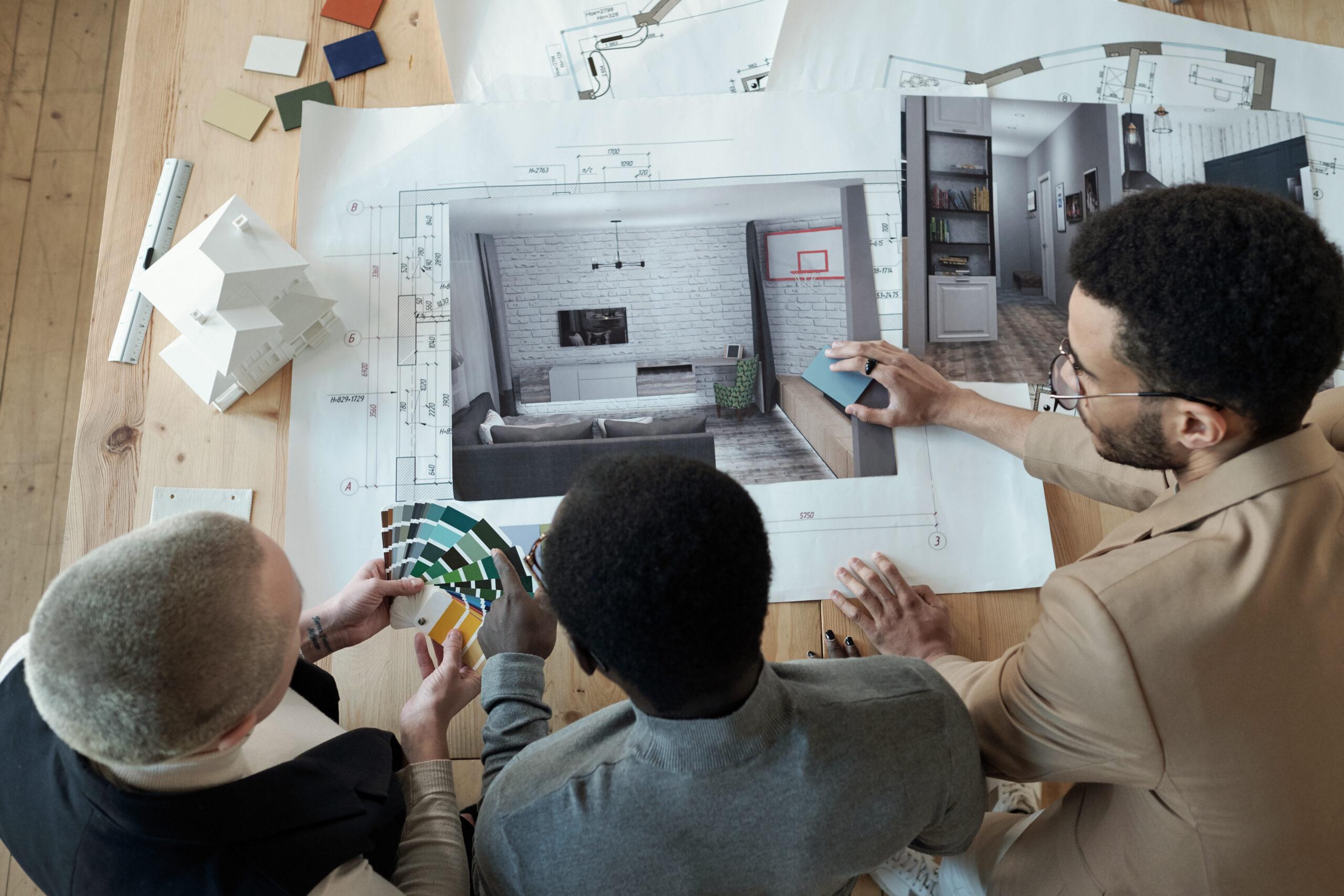 Homeowners studying kitchen renovation plans with a designer.