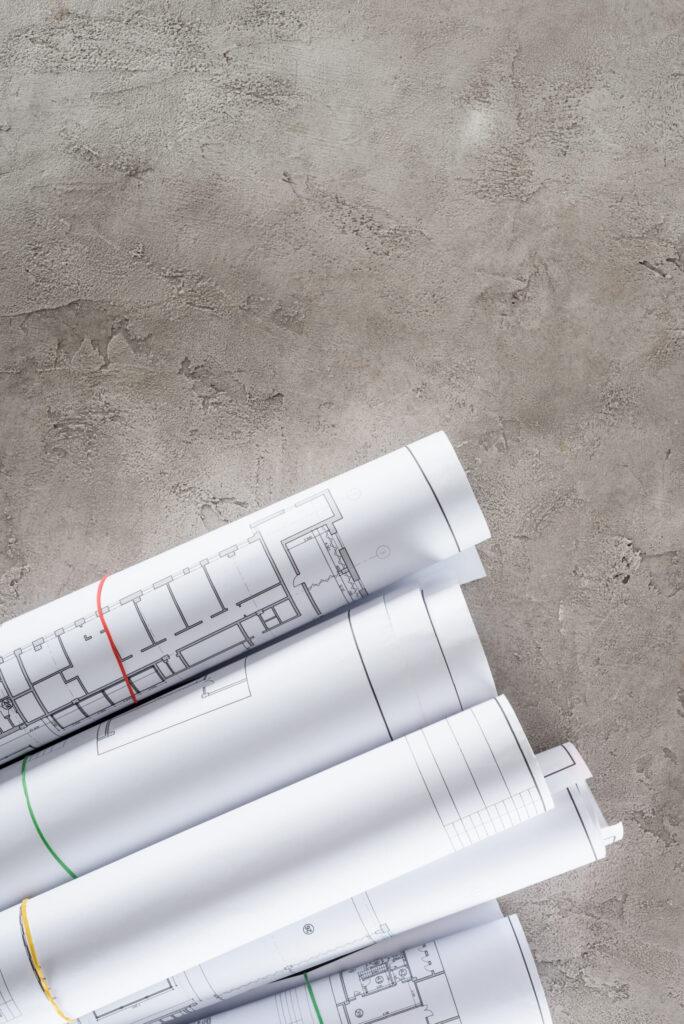 Architectural blueprints rolled on a construction surface.
